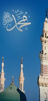 Mosque spires against a clear blue sky with Arabic script.