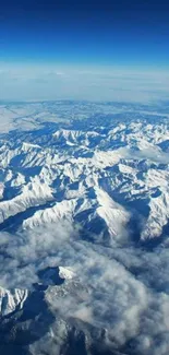 Aerial shot of snow-capped mountains under a clear blue sky.