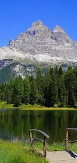 Calm lake with mountain and forest scenery under a clear blue sky.