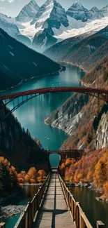 Scenic mountain bridge with autumn colors and snowy peaks.