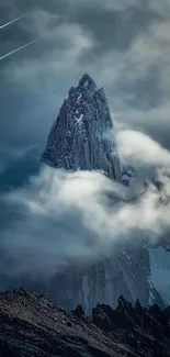 Majestic mountain peak shrouded in clouds with a dramatic sky backdrop.