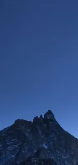 Majestic mountain at dusk under a deep blue sky.