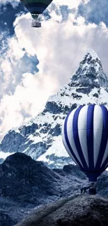 Hot air balloons float over a snow-capped mountain under a blue sky.