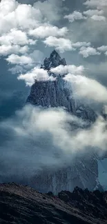 Mountain peak surrounded by clouds at dusk.