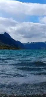 Majestic view of a mountain lake with blue sky and clouds.