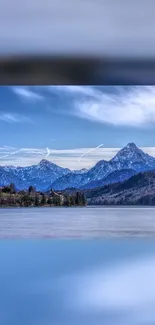 Majestic snowy mountain reflecting in a tranquil lake under a blue sky.