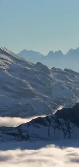 Serene mountain landscape with snow-capped peaks and a clear sky.