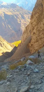 Person exploring stunning mountain cliff under bright sunlight.