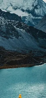 Person in yellow coat admiring a mountain lake.