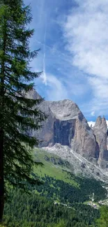 Majestic mountain landscape with green meadows and rocky peaks under a blue sky.