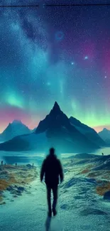 Silhouetted person under a breathtaking aurora-lit mountain night sky.