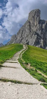 Pathway leading to rocky mountain under a blue sky.