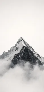 Mountain peak surrounded by clouds with gray tones.