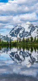 Peaceful mountain and lake with snow and blue sky reflected in water.