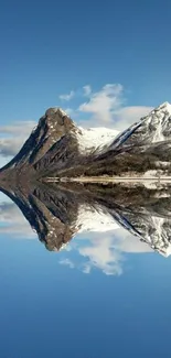 Majestic mountain reflection on serene waters under a clear blue sky.