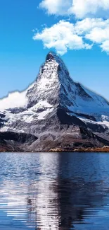 Snow-capped mountain reflecting on a calm lake with clear blue sky overhead.