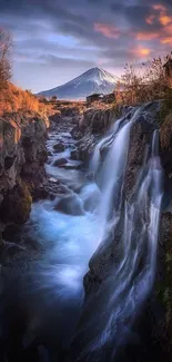 Mountain stream flows beside a snow-capped peak at sunset.