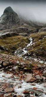 Scenic mountain landscape with flowing stream in rugged terrain.