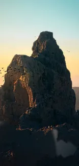 Majestic sunrise over a mountain peak with birds flying in a serene landscape.