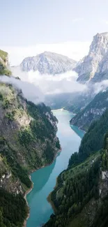 A breathtaking view of a mountain valley with a river flowing through lush greenery.