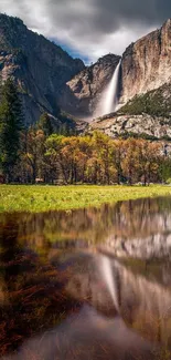 Stunning waterfall cascading down a mountain with reflection in a serene meadow.