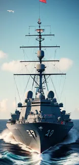 Naval ship cruising through the ocean under a bright blue sky.