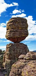 Majestic rock structure under vibrant blue sky with white clouds.