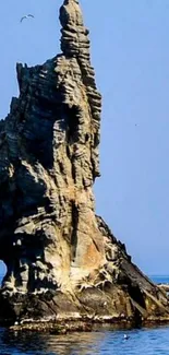 Majestic rock formation in tranquil blue sea.