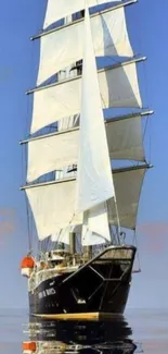 Majestic sailing ship with white sails on calm ocean near a clear blue sky.