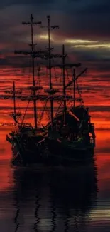 Silhouetted ship against orange sunset over calm ocean waters.