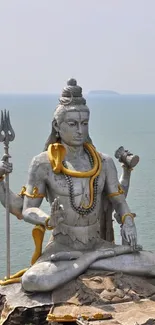 Majestic Shiva statue by the ocean, perfect for a serene mobile wallpaper.