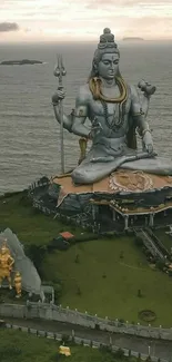 Majestic Shiva statue overlooking the ocean in serene landscape.