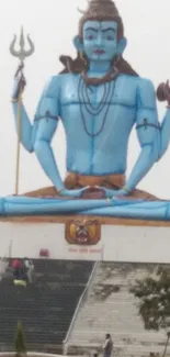 Majestic Shiva statue in blue with serene surroundings, perfect for mobile wallpaper.