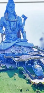 Majestic blue statue of Shiva with lush green surroundings.