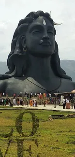 Majestic Shiva statue with a serene backdrop and LOVE text on grass.