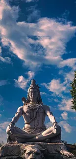 Shiva statue meditating under a cloudy sky with a serene ambiance.