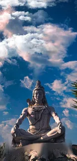 Lord Shiva statue with cloudy blue sky background.