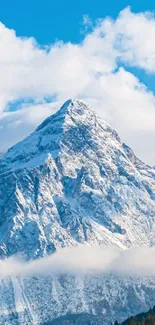 Snow-capped mountain under a blue sky with clouds.