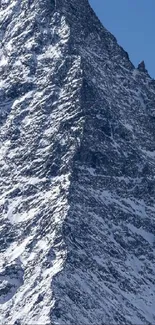 Snowy mountain peak against a clear blue sky.