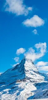 Majestic mountain peak under a blue sky with white clouds.