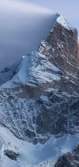 Snowy mountain peak with cloudy sky background.