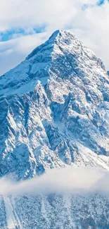 Majestic snow-covered mountain peak under a blue sky, creating serene scenery.