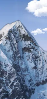 Snowy mountain peak with blue sky and clouds.