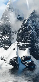 Snow-covered mountain peaks reflect in calm waters.