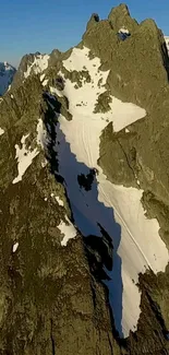 Snow-covered rocky mountain peaks under a clear blue sky.