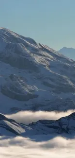 Snow-covered mountain peaks under clear blue sky.