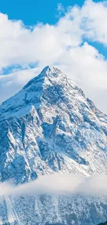 Majestic snowy mountain peaks under a blue sky with fluffy clouds.