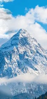 Snowy mountain peak under blue sky with clouds.