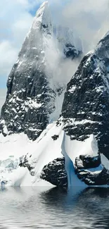 Majestic snowy mountain peak reflected on calm water.