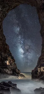 Starry night sky through cave opening with visible rocky formations.